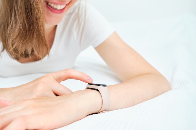 Girl smiles and uses a smart watch