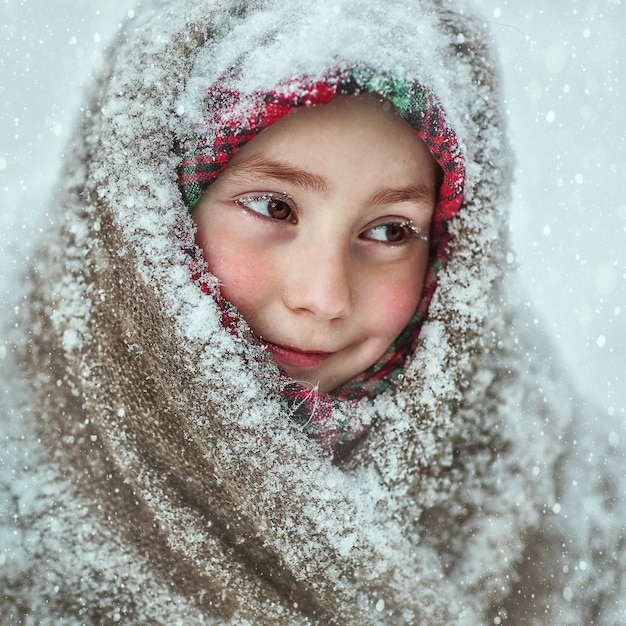 A girl in a snow-covered scarf with a smile on her face