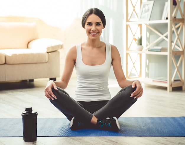 Girl in sportswear sitting in lotus position