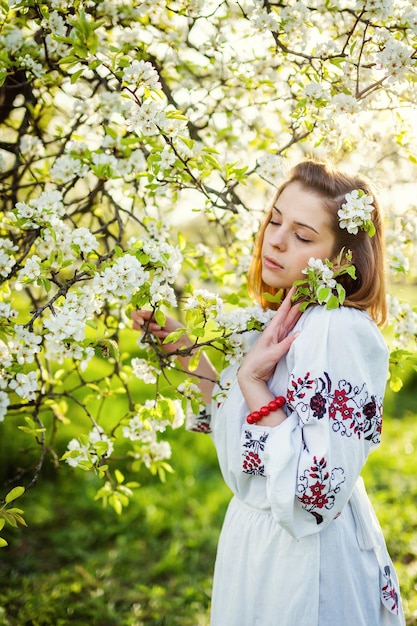 The girl in the spring morning in a beautiful flower garden holding bouquet of flowers in their hands