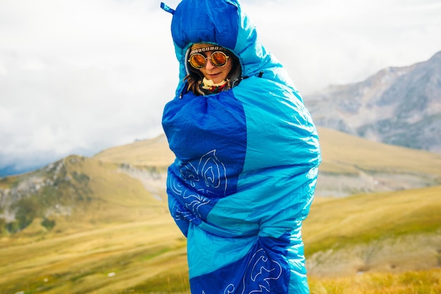 Girl standing in a blue sleeping bag on the nature High quality photo