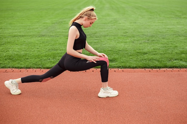 Girl stretches at the stadium