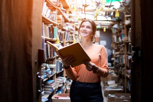 Girl student reads a book in the library