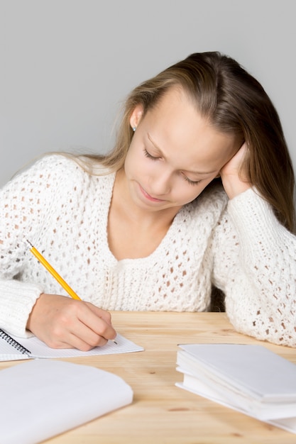 Girl studying on a wooden table