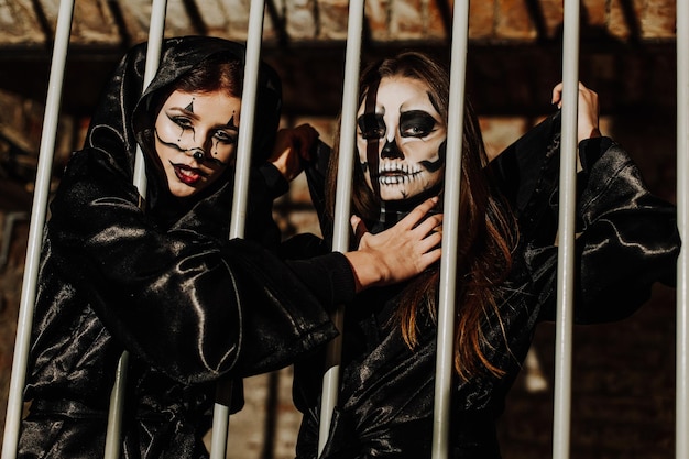 A girl in stylish top hat with skull make up and tattoo on arm Halloween party