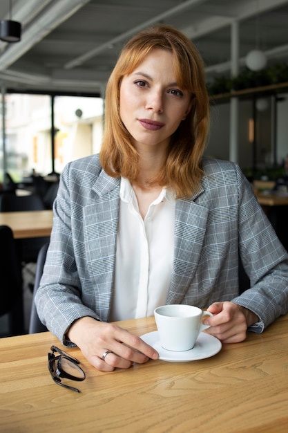 Girl in a suit with a cup of coffee