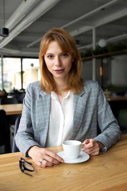 Girl in a suit with a cup of coffee