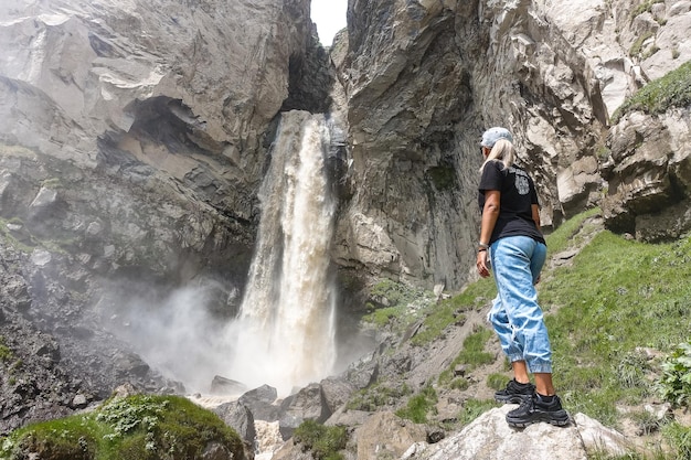 A girl at the Sultansu waterfall surrounded by the Caucasus Mountains near Elbrus Jilysu Russia