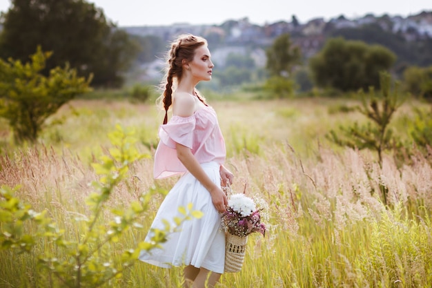 girl in the summer field with a bouquet