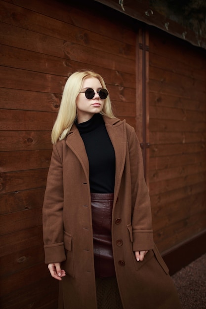 Girl in sunglasses on the wooden background.