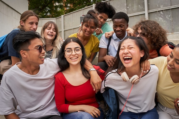 A girl surrounded by classmates looking at a smiling camera happy students in high school