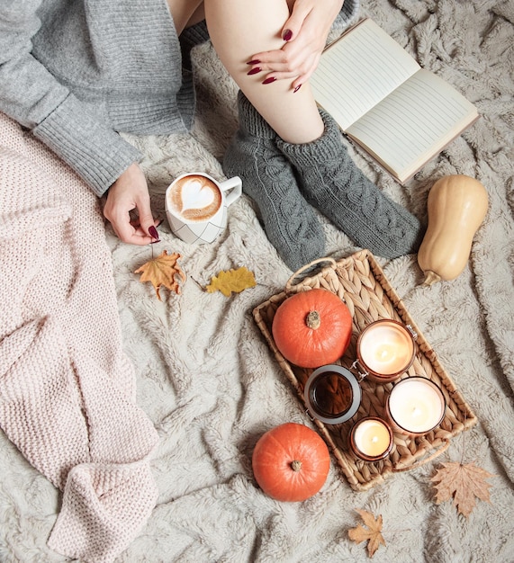 A girl in a sweater and knitted socks sits on a blanket