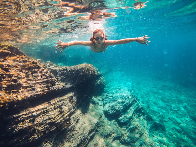 Girl swimming in the sea by the reef