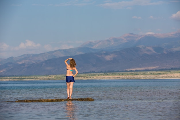 Girl in a swimsuit on a mountain lake