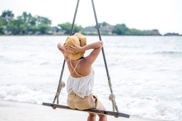 girl on a swing on the beach of Thailand