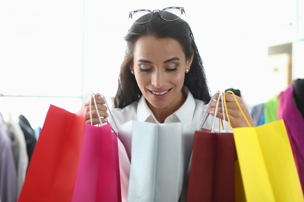 Girl takes pleasure from shopping at boutique.