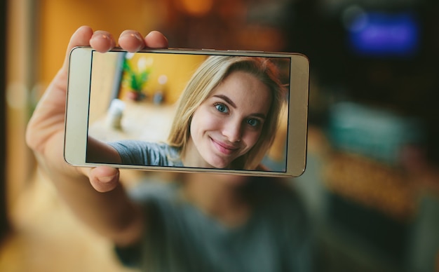 Girl taking photo of her face on mobile phone