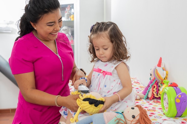 Girl taking the temperature of her wrist while she is in consultation with her pediatrician doctor