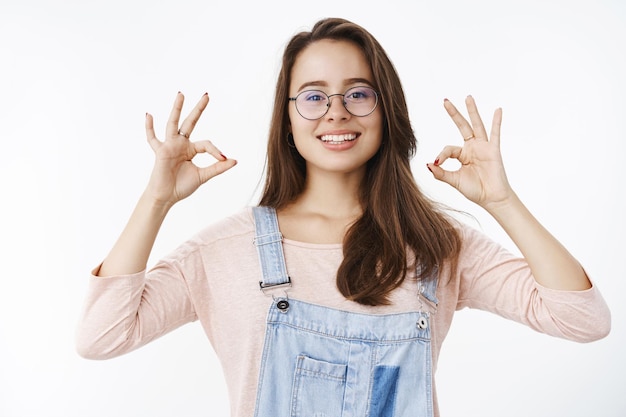 Girl taking things under control assuring plan goes okay showing ok gesture and smiling in approval