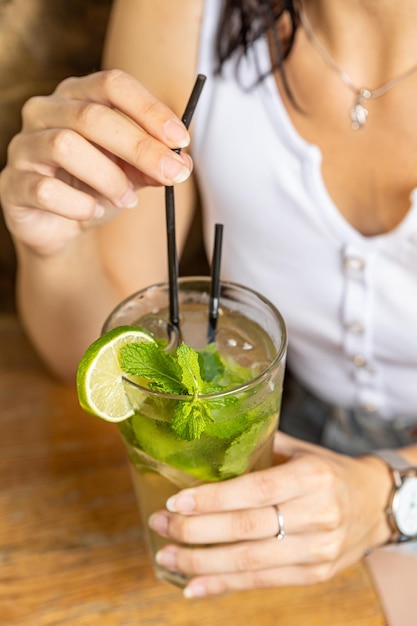 The girl tastes a cocktail at the restaurant bar