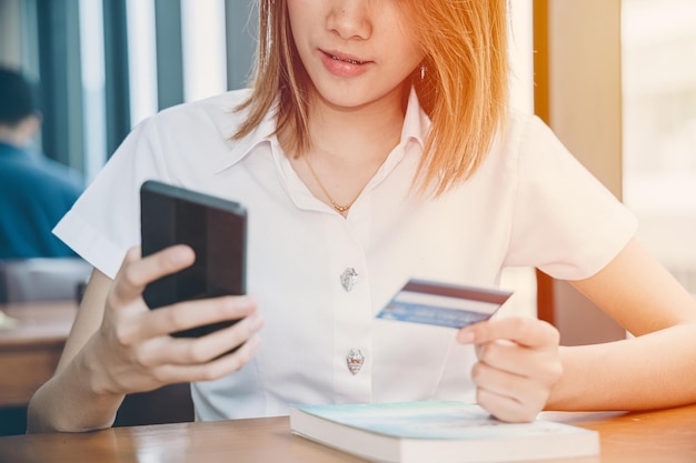 Girl teen using smart phone to online shopping credit card payment platform university uniform model.