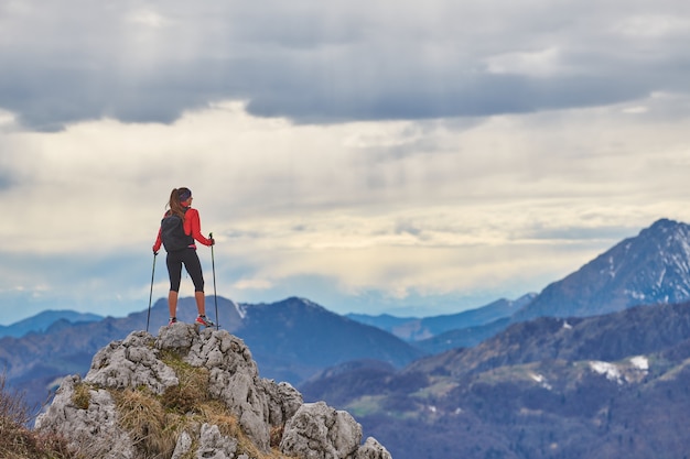 Girl on top of a mountain alone observes the view