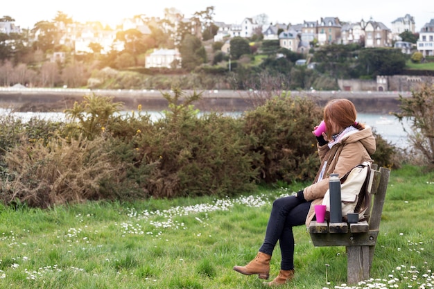 Girl tourist rests on a bench and drinks tea