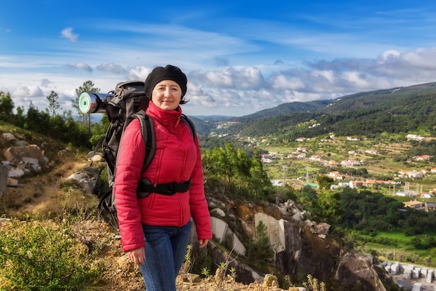 Girl tourist with a backpack in the campaign. With views of the Monchique.