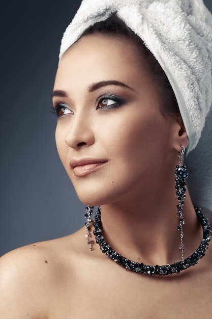 Girl in towel with earrings and necklace