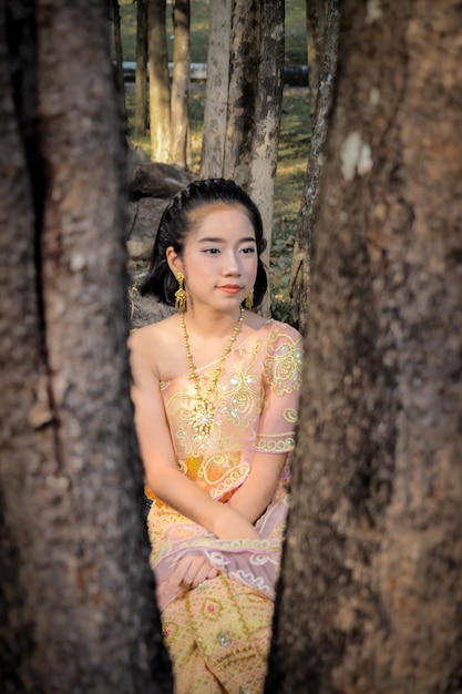 Photo girl in traditional clothing sitting at park