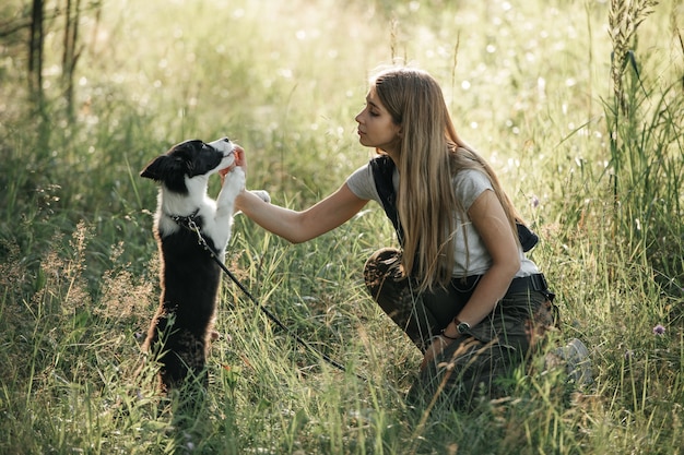 Girl training black and white border collie dog puppy