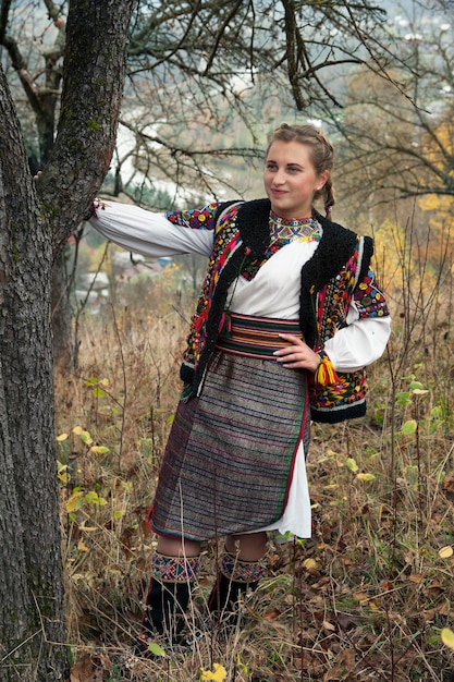 A girl in Ukrainian national clothes in an apple orchard