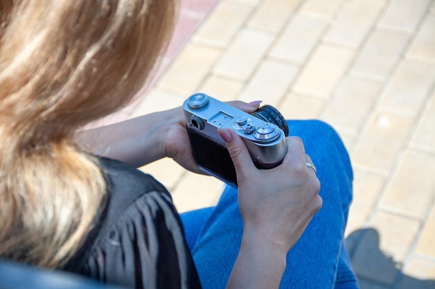 girl uses a camera, camera in hands, a man in the park, a hobby