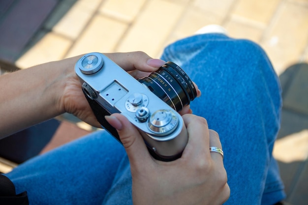 girl uses a camera, camera in hands, a man in the park, a hobby