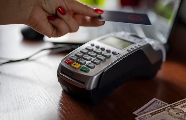 The girl uses the terminal to pay for cashless payments using the bank card system