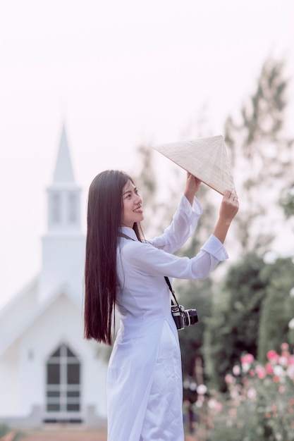 Girl in Vietnam's national costume Standing with a hat to smile happily