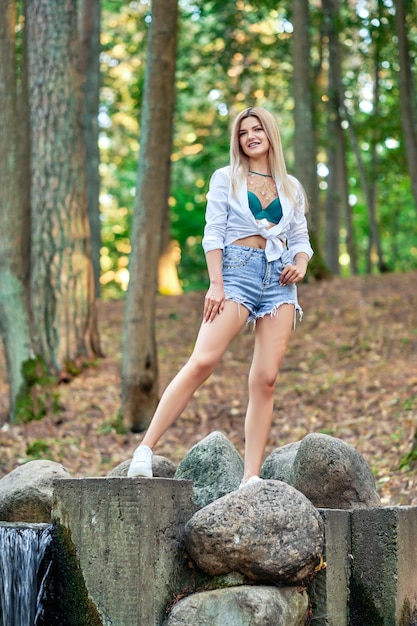 Girl walking in park along stones surrounding artificial creek