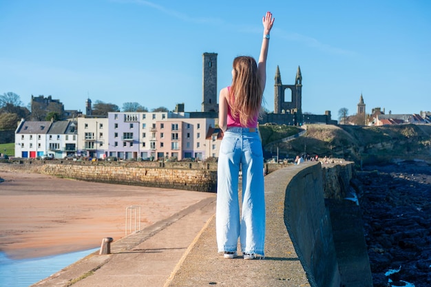 A girl walks along the promenade in the city of St Andrews in the UK