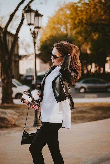 a girl walks around the city. a girl with a magazine. city walk