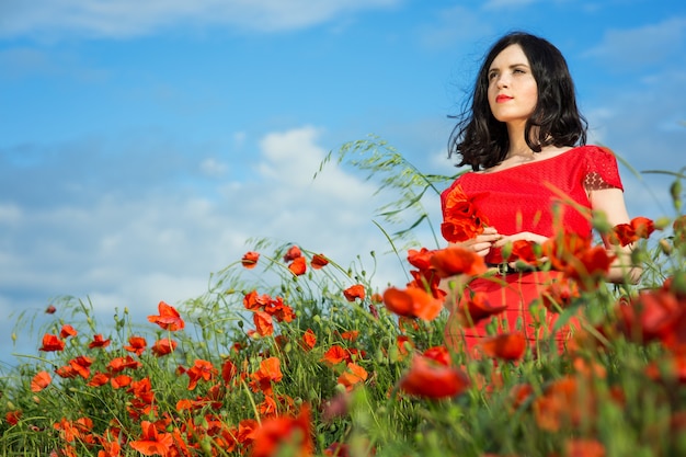 Girl walks in a field of poppies