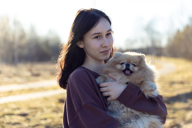 A girl walks with a dog in the park outdoor recreation with a pet a portrait with a small puppy