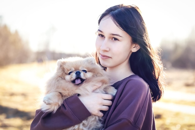 A girl walks with a dog in the park outdoor recreation with a pet a portrait with a small puppy