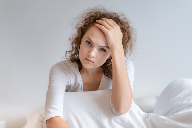 The girl was sitting in the bed. She was stressed.