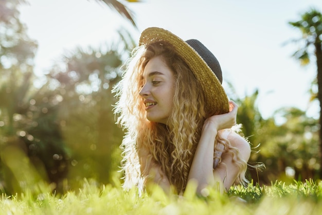 Girl watching insects in the grass lying on her stomach in the park