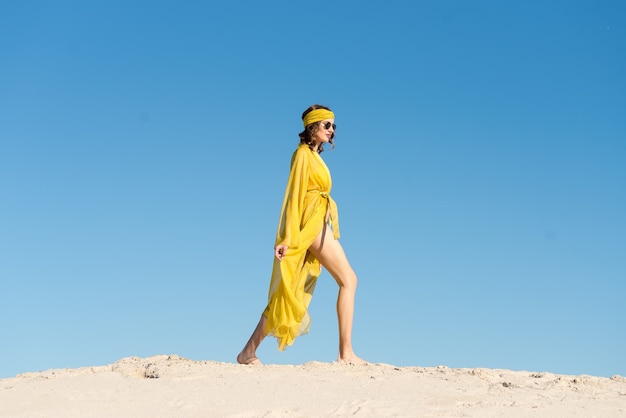 Girl wearing beach wear and posing at the sandy beach