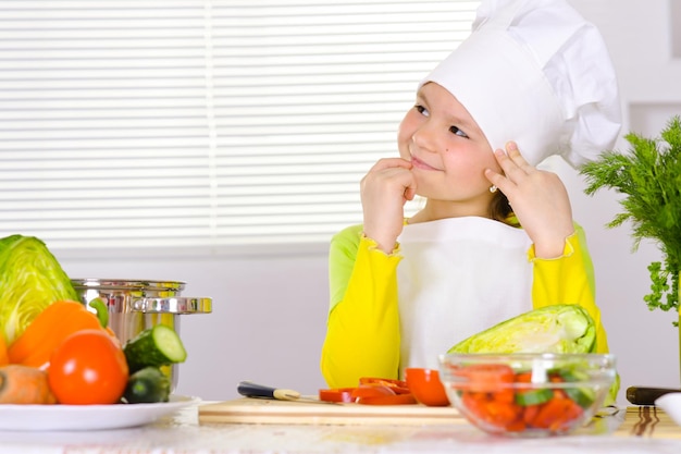 Girl wearing chef uniform cooking on kitchen