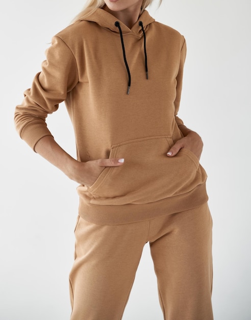 Girl wears light brown hoodie and pants isolated photo of women wearing nude color fleece textile outfit