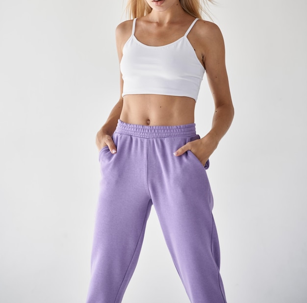 Girl wears violet pants with white top crop fit woman standing in casual clothes