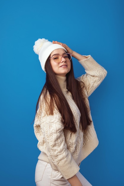 Girl wears warm hat and oversized knitted sweater feels joyful enjoy winter