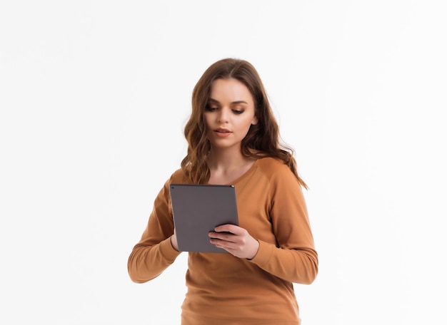 The girl on a white background looks into the tablet